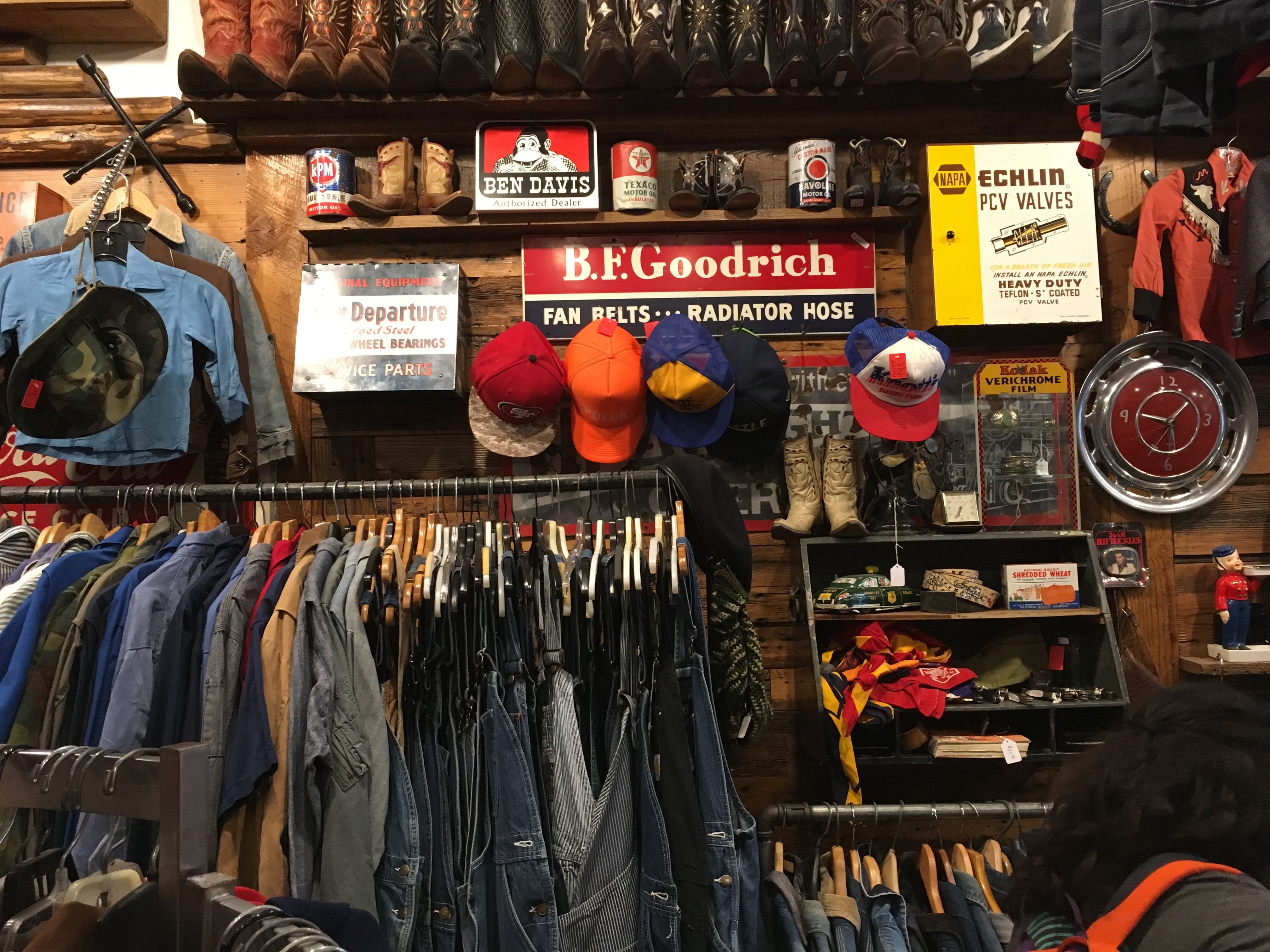 Vintage clothing store with racks of denim, vintage signs, caps and accessories
